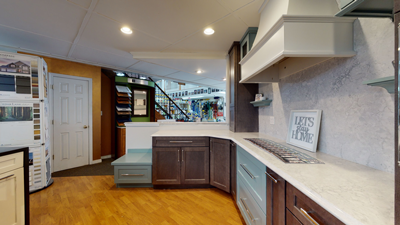 modern kitchen showroom with wooden cabinets, white countertops, and bright lighting
