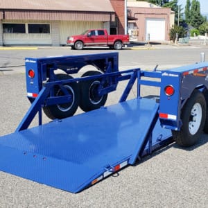 blue trailer with flatbed and dual wheels parked on street