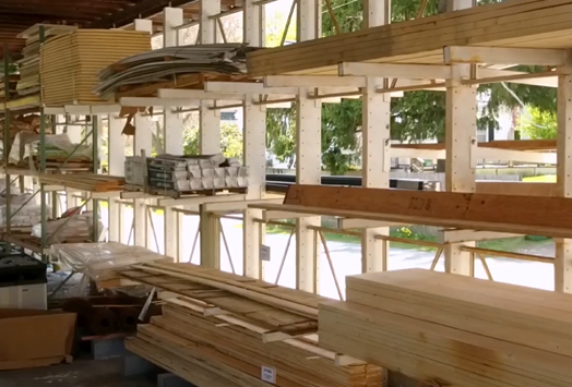 Construction site with wooden beams and metal materials stacked in a partially built structure.