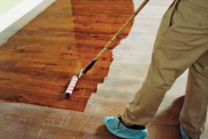 Koopman applying finish to a wood floor