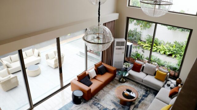This image depicts a modern living room that features large windows to create an inviting, airy space.