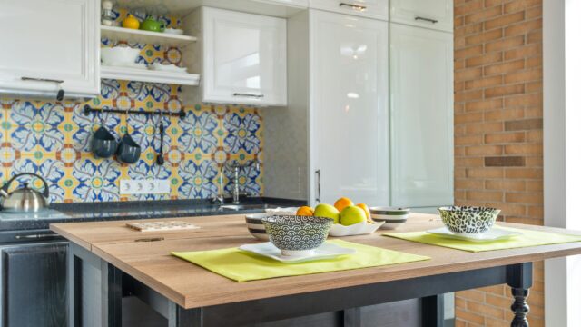 Kitchen utensils hang below open shelves, offering convenient storage in a stylish kitchen.