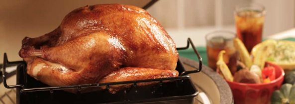 Golden roasted turkey in a roasting pan, perfect for a holiday feast, resting on the kitchen counter.