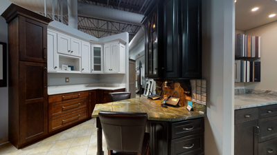 Showroom with various kitchen cabinet styles and finishes, including white, dark wood, and sample panels on display.