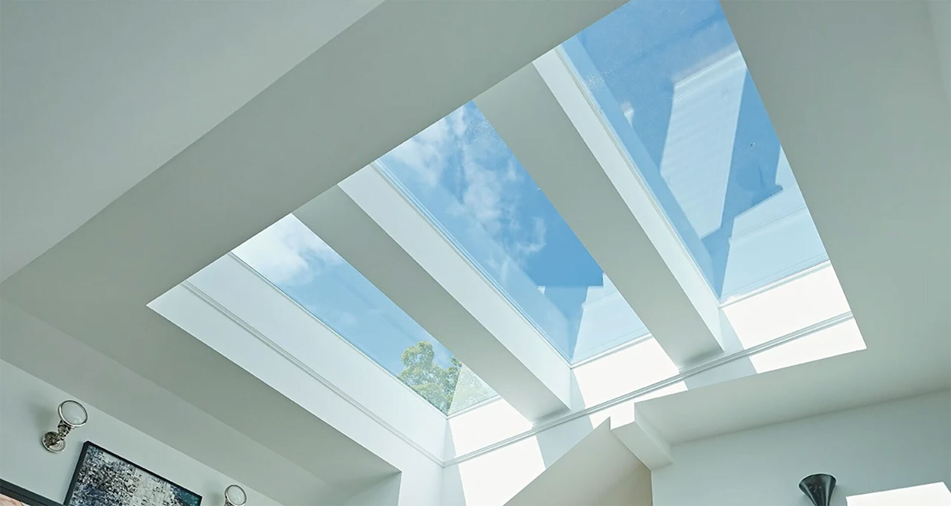 modern skylight with blue sky and clouds visible through large glass panels